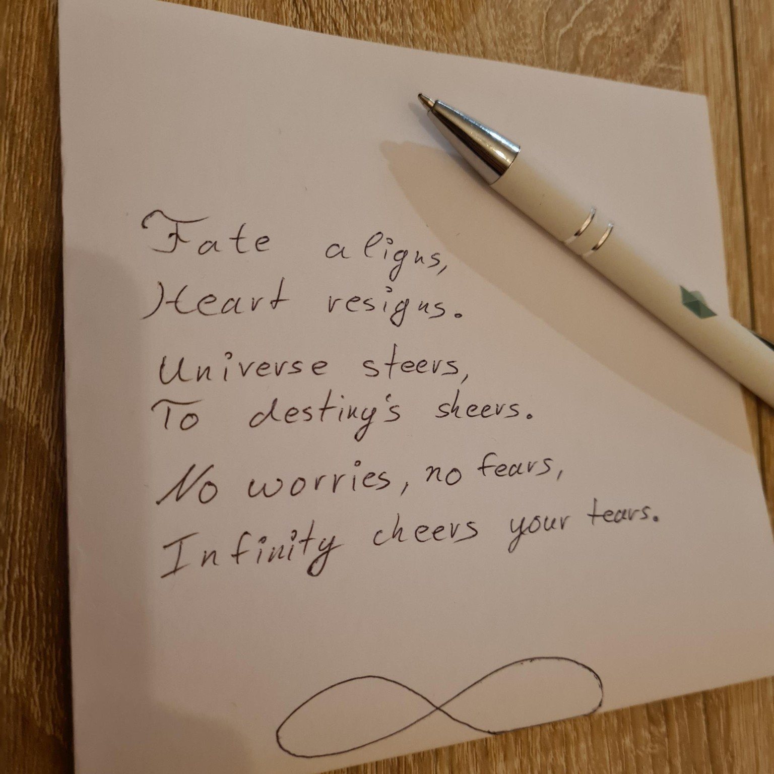 A handwritten poem by Diana S. Engelhard beside a pen on a wooden table.