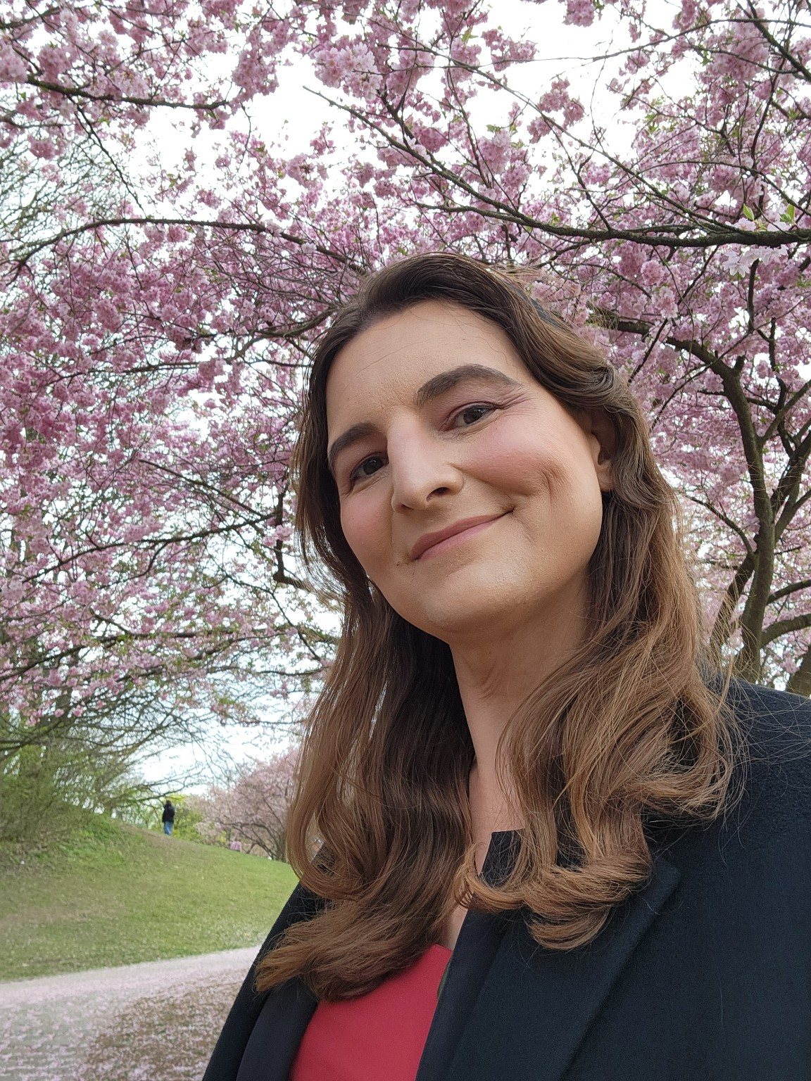 Diana S. Engelhard beneath flowering cherry trees.